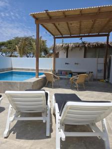 - deux chaises et une piscine dans l'établissement Casa Siena Vichayito a poco metros del mar, à Organos