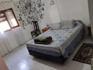 ein Schlafzimmer mit einem Bett und einem Kissen darauf in der Unterkunft Azulina in Alta Gracia