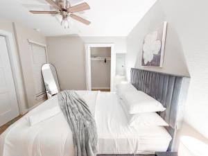 Un dormitorio blanco con una cama y un ventilador de techo. en Comfy 1BR Apt Near ATT Six Flags, en Grand Prairie