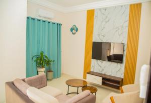 a living room with a couch and a television at Sika Résidence Bénin in Cocotomey