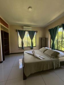 a bedroom with a large bed with green curtains at Casa Susan in San Pedrillo