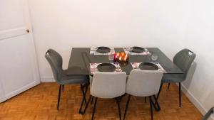 ein Esstisch mit vier Stühlen und ein Tisch mit Kerzen in der Unterkunft Villa Horizon in Champs-Sur-Marne
