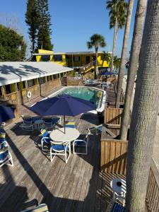 a patio with a table and chairs and a pool at Barefoot Bay Resort Motel in Clearwater Beach