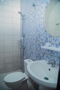 a bathroom with a sink and a toilet and a mirror at Sika Résidence Bénin in Cocotomey +32 photos