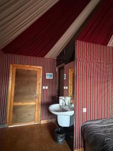 a room with a sink and a bed and a bathroom at Bubbles Desert Camp Jeep Tours in Wadi Rum