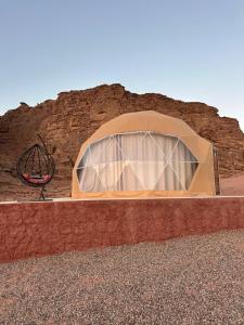 a small tent in front of a rock wall at Bubbles Desert Camp Jeep Tours in Wadi Rum