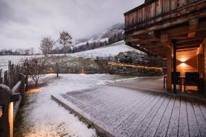 a building with snow on the ground next to a field at Luxury Naturperle Haus Alpenprinzessin helles Holzhaus zentral , modern & großräumig in Neustift im Stubaital