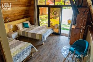 ein Zimmer mit 2 Betten und einem Stuhl darin in der Unterkunft Cabañas Alpinas en Oxapampa in Oxapampa