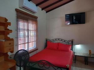 a bedroom with a red bed and a window at Diamond Breeze - Fully furnished apartment in Port-of-Spain