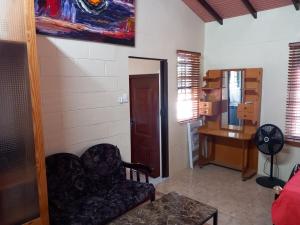 a living room with a chair and a desk at Diamond Breeze - Fully furnished apartment in Port-of-Spain