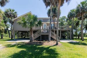 ein Haus mit Palmen davor in der Unterkunft Island Gossip in Edisto Beach