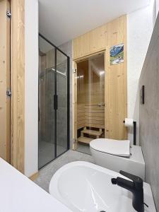 a bathroom with a white toilet and a sink at Chalet Sole delle Dolomiti in Varda