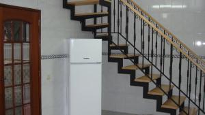 a white refrigerator next to a spiral staircase at Casa de Férias Azeitão in Azeitao