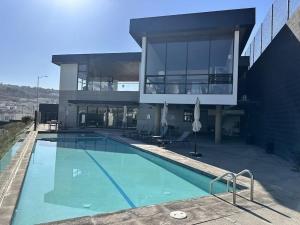 a large building with a swimming pool in front of it at Amar Apartment - 24 hour security, Comfort in Tijuana