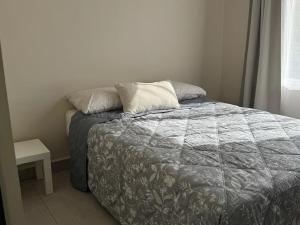 a bed with two pillows on it in a bedroom at Amar Apartment - 24 hour security, Comfort in Tijuana +35 photos
