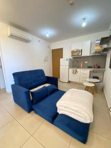 Un sofá azul en una sala de estar con cocina. en Equipped studio, balcony and garage - Asuncion, en Asunción 24 fotos más