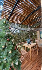 un sapin de Noël sur une terrasse avec une table dans l'établissement Casa del Árbol Sesquile, à Tres Esquinas