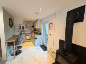 - une cuisine avec une cuisinière au milieu d'une pièce dans l'établissement Cardiff Coach House with Hot Tub & Log Fire, à Cardiff