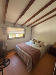 Un dormitorio con una cama grande con ventana. en Refugios Pisco Elqui Lodge, en Pisco Elqui