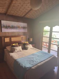 Un dormitorio con una cama grande con un cuadro en la pared. en Refugios Pisco Elqui Lodge, en Pisco Elqui