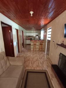a living room with a couch and a kitchen at Sítio jaguary in Camanducaia