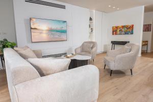 un salon avec un canapé, deux chaises et une table dans l'établissement מיקונוס על הים נהריה, à Nahariya