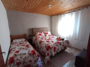 ein Schlafzimmer mit zwei Betten und einem Fenster in der Unterkunft Sítio jaguary in Camanducaia