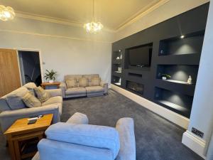a living room with two couches and a flat screen tv at Bay Apartment in Morecambe
