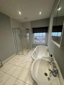 a bathroom with a tub and a sink and a shower at Bay Apartment in Morecambe +4 photos