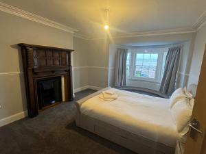 a bedroom with a large bed and a fireplace at Bay Apartment in Morecambe