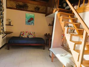 une chambre avec un lit et un escalier en colimaçon dans l'établissement La PERLE de MOOREA Fare HONU Bord de Lagon, à Orufara
