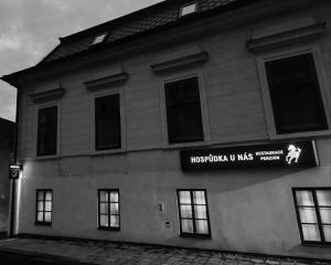 a building with a sign on the side of it at Penzion u Nás u Hospůdky in Žatec