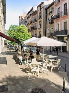 a group of tables and chairs with umbrellas on a street at Vive Zaragoza XV in Zaragoza +27 photos