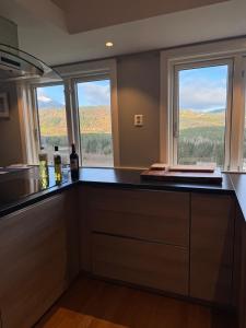 a kitchen with a counter with two windows in it at Breathtaking Voss Views - Spacious Family Home in Vossevangen