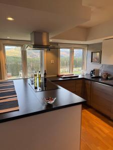 a kitchen with a black counter top and some windows at Breathtaking Voss Views - Spacious Family Home in Vossevangen