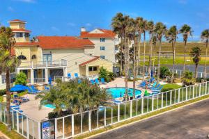 a resort with a swimming pool and palm trees at Beach Club 280 in Padre Island