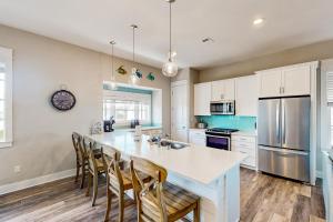 马士腾海滩Perfect Pelican at Palmilla Beach的厨房配有带椅子的大厨房岛