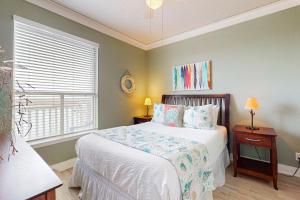 パドレ・アイランドにあるBeach Club - Resting Beach Faceのベッドと窓のある寝室 +18枚の写真