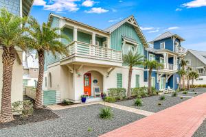 una fila de casas con palmeras delante en Coastal Happy Ours at Palmilla Beach, en Mustang Beach