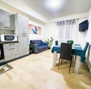 a kitchen and living room with a blue table and chairs at Residenza India in Avezzano