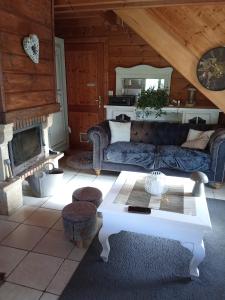 a living room with a couch and a fireplace at studio Nature & détente in Puessans