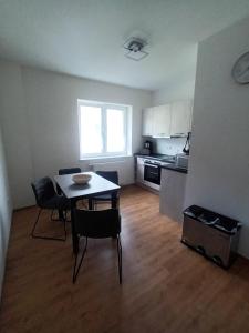 Una sala de estar con mesa y sillas y una cocina. en Schöne Wohnung mit WLAN und Balkon in Magdeburg Salbke, en Magdeburgo