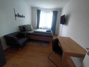 una pequeña sala de estar con sofá y silla en Schöne Wohnung mit WLAN und Balkon in Magdeburg Salbke, en Magdeburgo