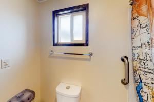 Un baño con inodoro y ventana. en Lamplighter Inn - 116 Crab Shack, en Bandon
