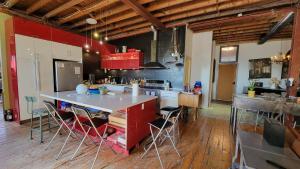 Eine Küche mit roten Schränken und einer großen Kochinsel mit Barhockern. in der Unterkunft Unique Above Garage Loft in Toronto + 7 Fotos