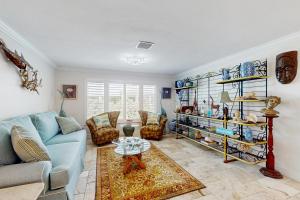 ein Wohnzimmer mit einem blauen Sofa und einem Tisch in der Unterkunft Shell Seeker in Bowmans Beach Helistop