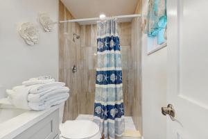 ein Bad mit einem Duschvorhang und einem WC in der Unterkunft Shell Seeker in Bowmans Beach Helistop + 11 Fotos