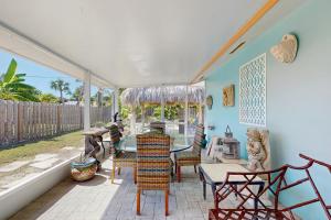 Zimmer mit einem Tisch und Stühlen auf einer Terrasse in der Unterkunft Shell Seeker in Bowmans Beach Helistop