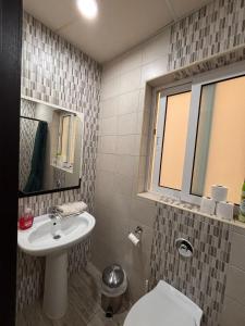 a bathroom with a sink and a toilet and a mirror at Sliema Central with Balcony Airconditioned and Comfortable Self Check IN in Il-Gżira