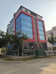 a large building with glass windows on a street at Stay Homie - 1BHK, Near ISB Airport, Self Check-In, Secure in Islamabad